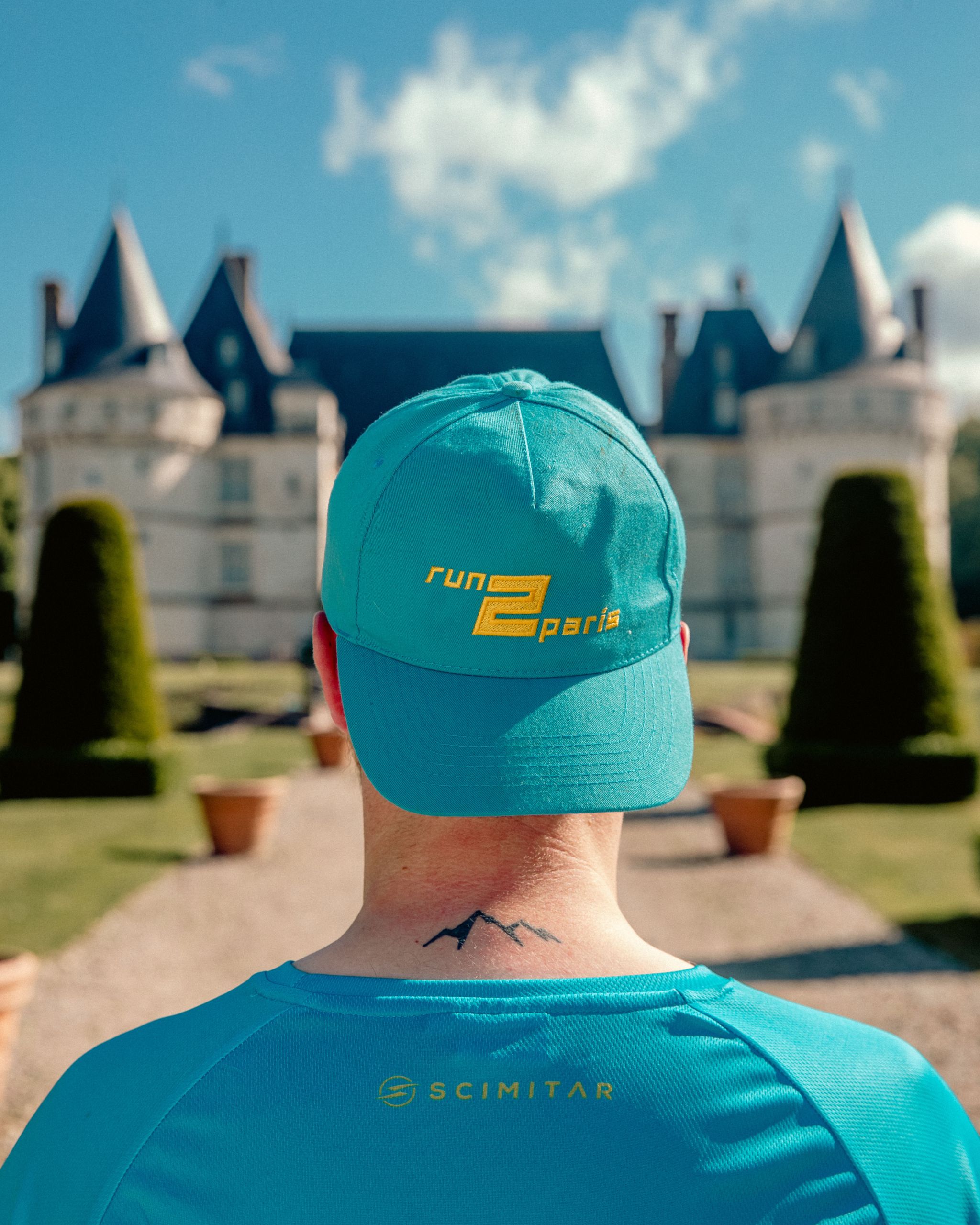 Run2paris relay run from London to Paris participant with blue cap and mountain tattoo.