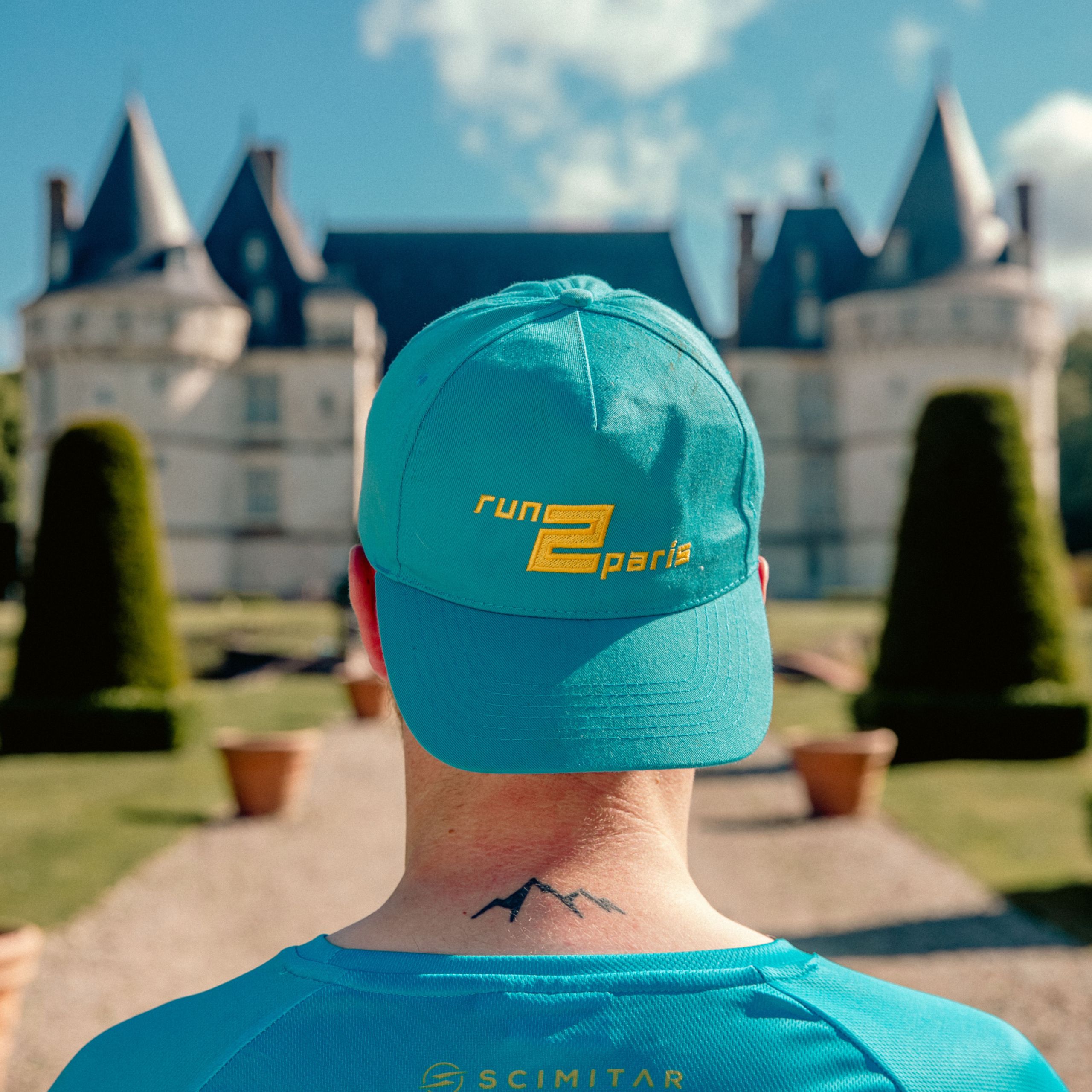Run2paris relay run from London to Paris participant with blue cap and mountain tattoo.