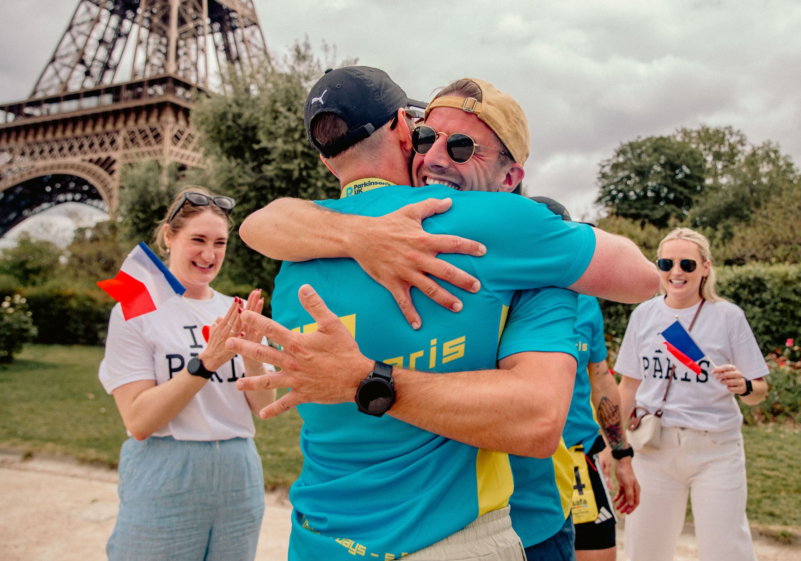 Hugging runners at the Eiffel Tower during Run2Paris relay event in France.