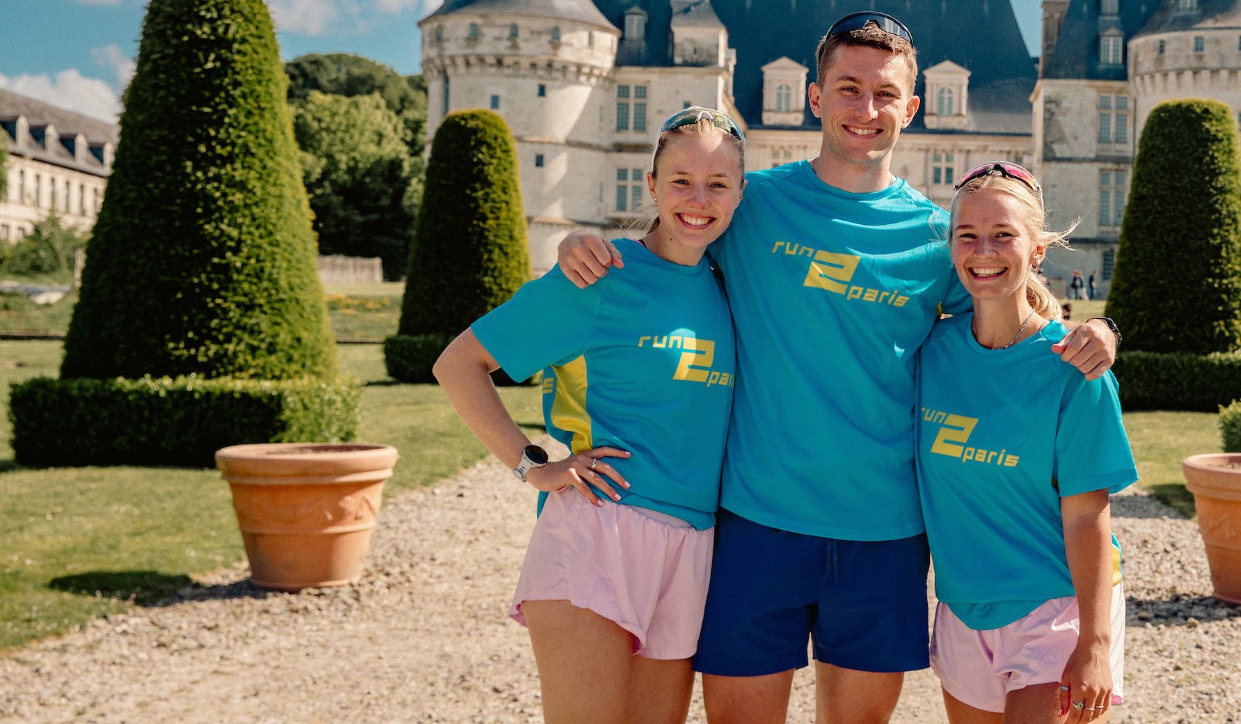 - Relay runners celebrating in front of a historic castle in Paris.
