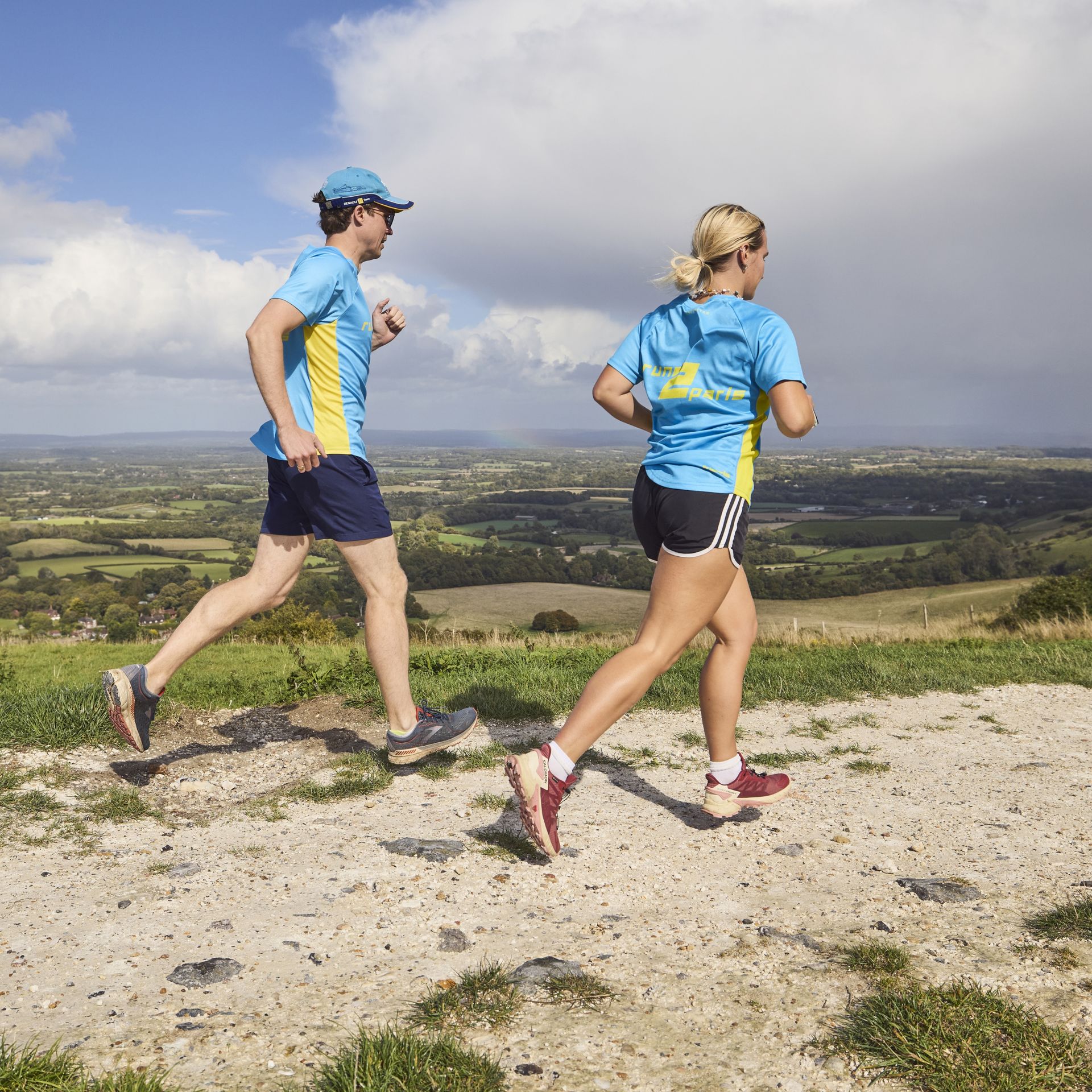 Runners participating in the Run2Paris relay race from London to Paris, running through scenic countryside.