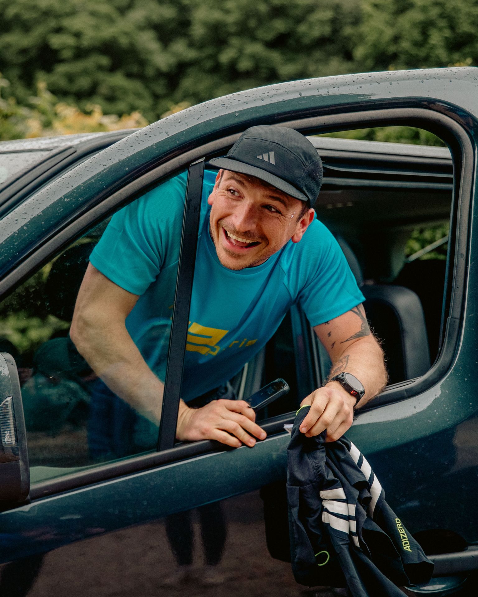 Happy runner smiling from vehicle window after relay run.